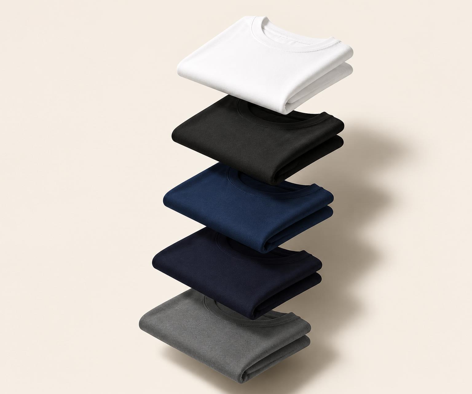 Five floating folded basic T-shirts in white, black, navy, deep navy and grey